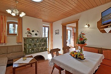 Ferienwohnung in Alpbach - Wohnraum mit Sitzecke, Flat-TV und Kachelofen
