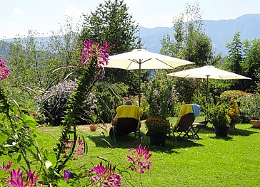 Ferienwohnung in Seeboden - Garten mit Liegestühlen und Sonnenschirmen