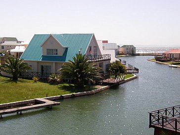 Ferienhaus in Jeffreys Bay - Seitenansicht vom Haus mit Grünfläche, Kanal und