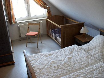 Ferienhaus in Nessmersiel - Elternschlafzimmer mit Doppelbett, Kinderbett