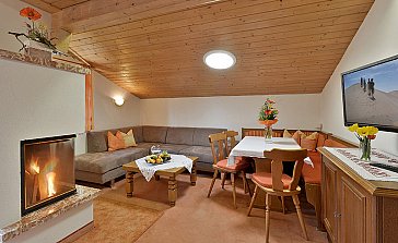 Ferienwohnung in Alpbach - Wohnraum mit Sitzecke, Flat-TV und offenem Kamin