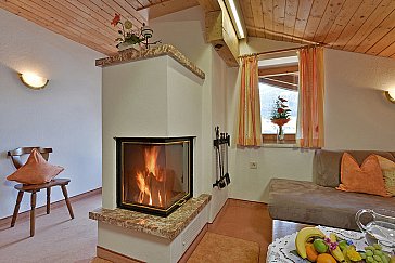 Ferienwohnung in Alpbach - Wohnraum mit Sitzecke, Flat-TV und offenem Kamin