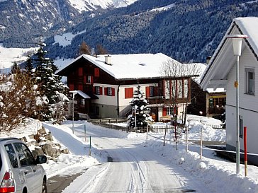 Ferienhaus in Lumbrein - Westfassade mit Parkplatz im Winter