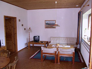 Ferienhaus in Rechlin - Wohnzimmer mit Essecke (links), Fenster zum Garten