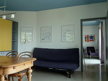 Ferienwohnung in Locarno-Muralto - Wohnzimmer mit Holztisch, Schlafsofa und Schrank