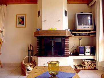 Ferienwohnung in Bellwald - Wohnzimmer mit Esstisch und Cheminée