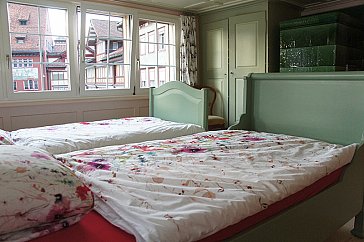 Ferienwohnung in Appenzell - Zimmer mit zwei Betten, Wandschrank, Kachelofen