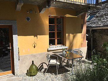 Ferienhaus in Tegna - Sitzplatz mit Tisch, 2 Liegen und Grill