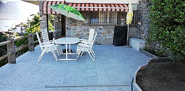 Ferienwohnung in Caviano - Terrassenplatz mit Tisch und Stühlen, Grill